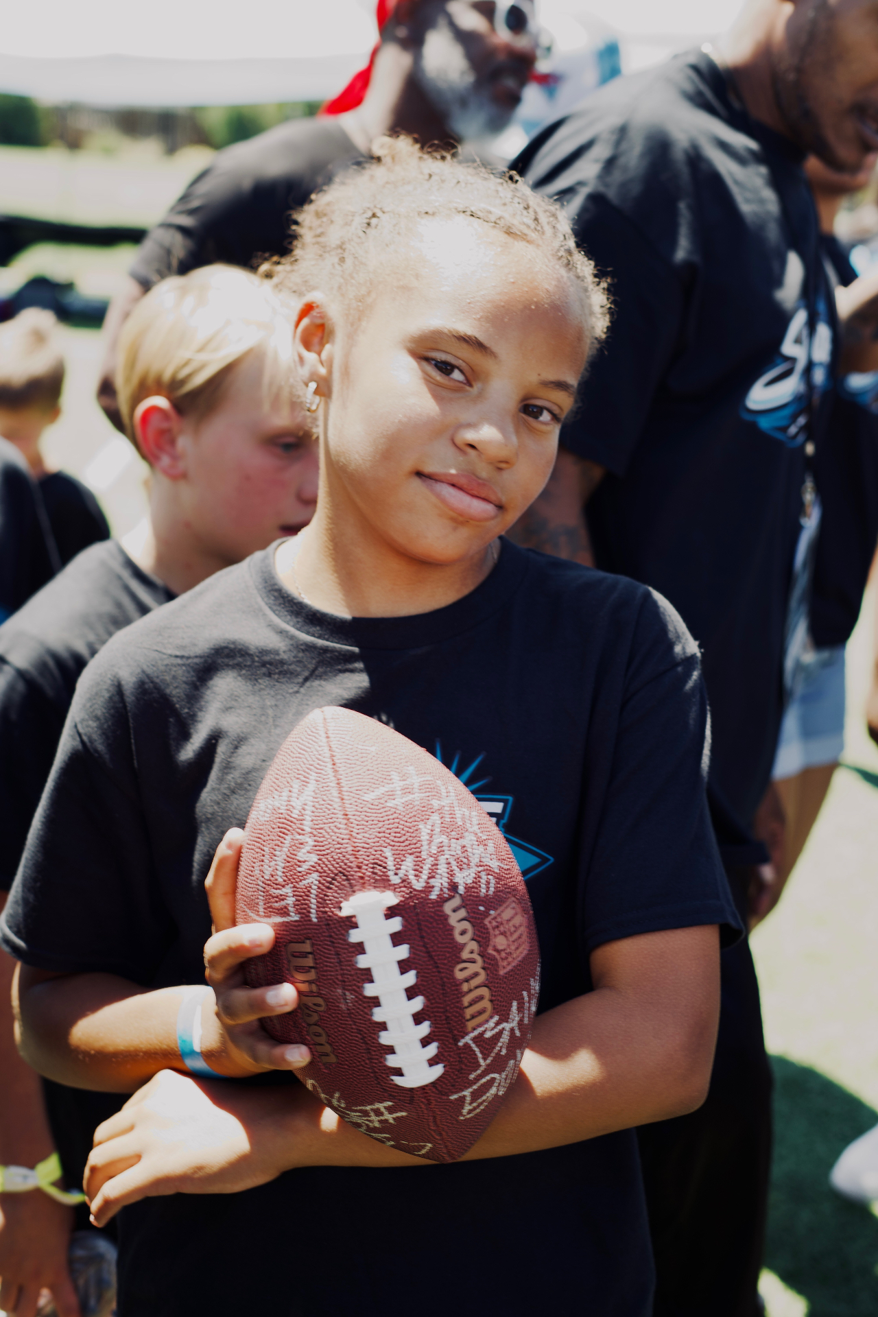 Young camper holding a signed football