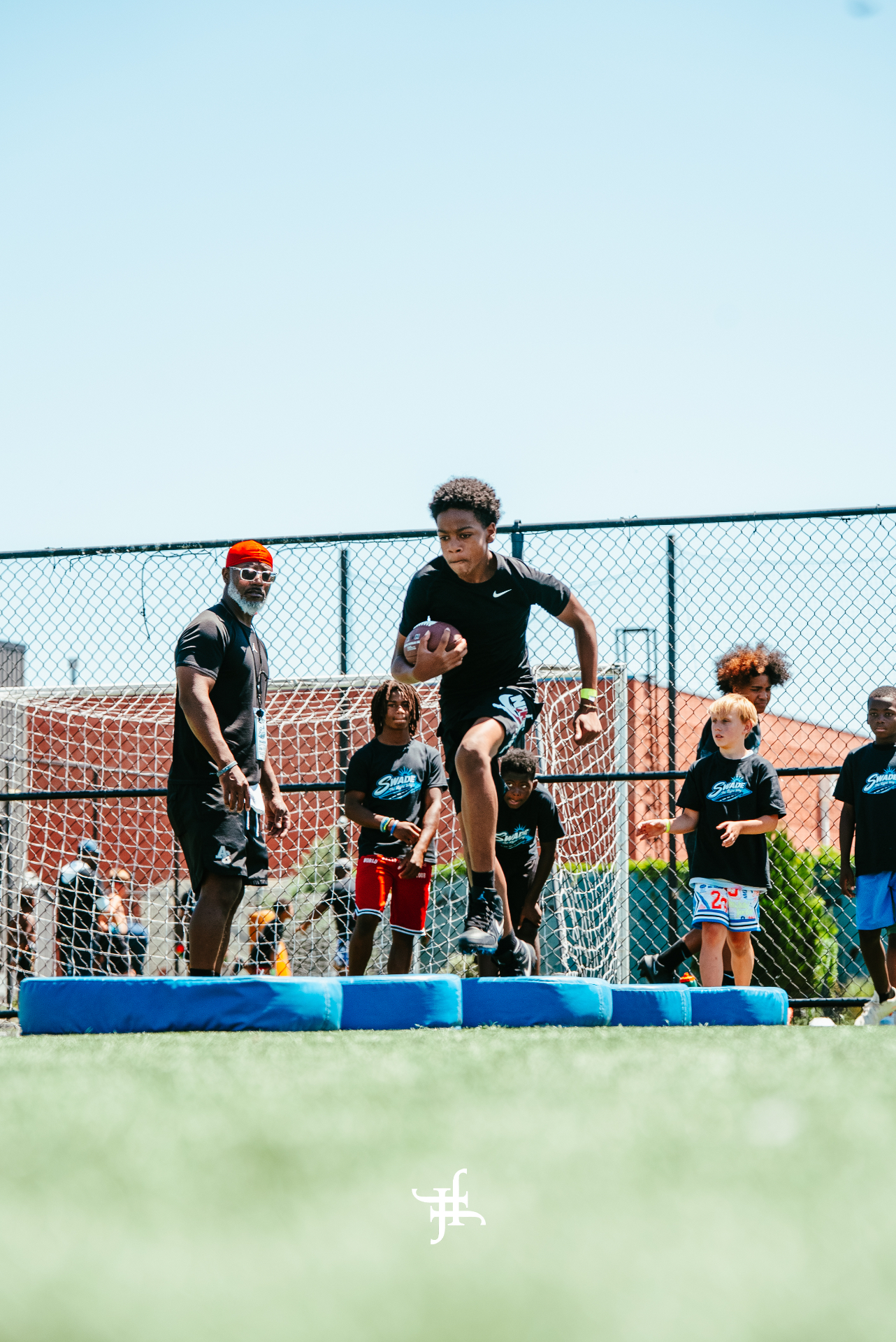 Camper leaping over pads during an agility drill