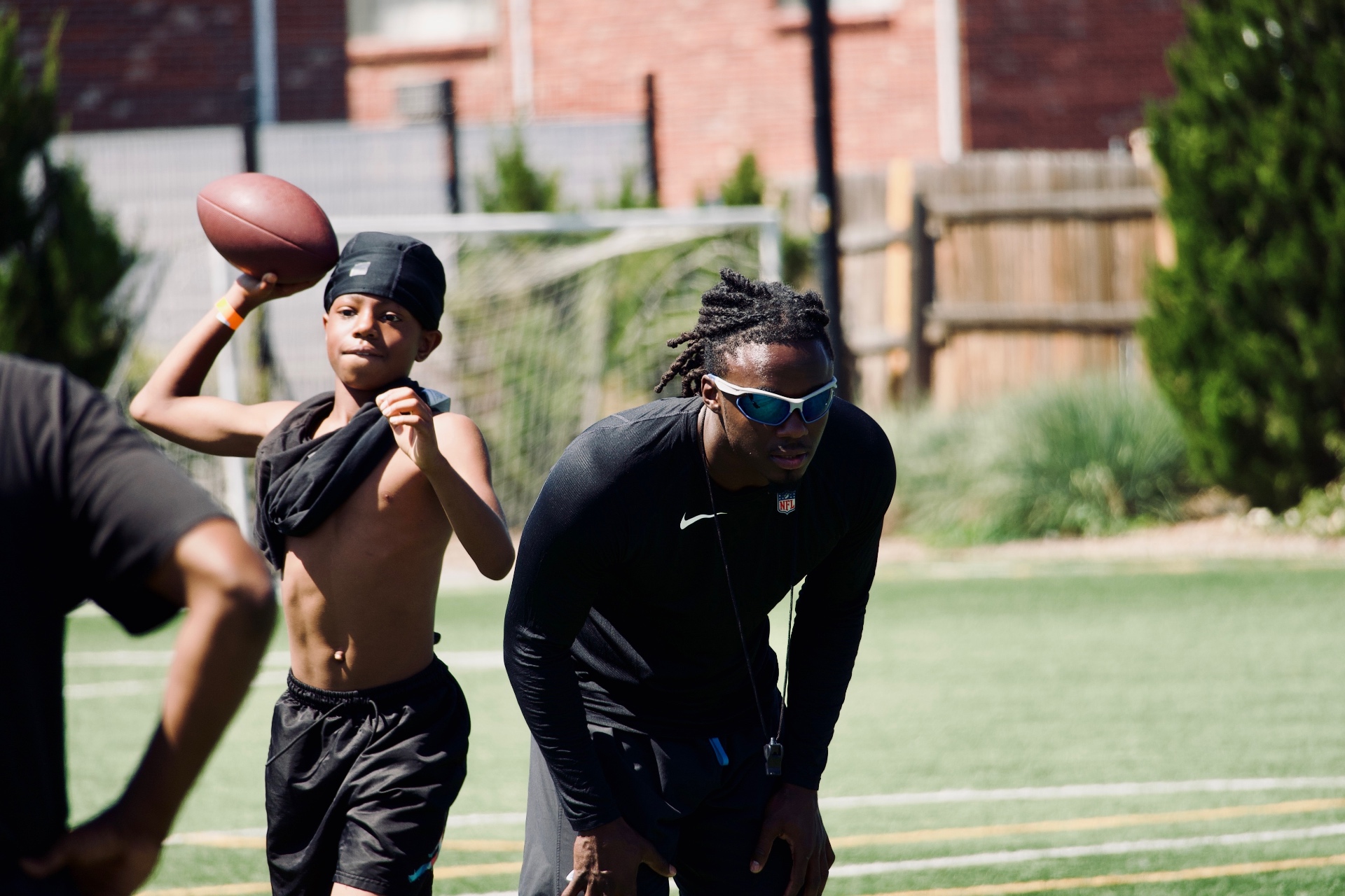 Camper throwing a football under Chau's guidance